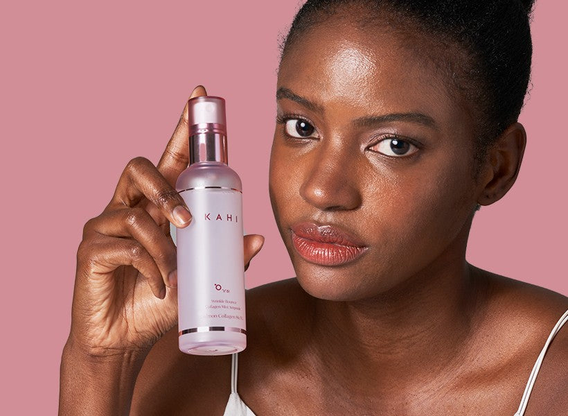 Woman holding the KAHI Collagen Mist Ampoule bottle beside her face
