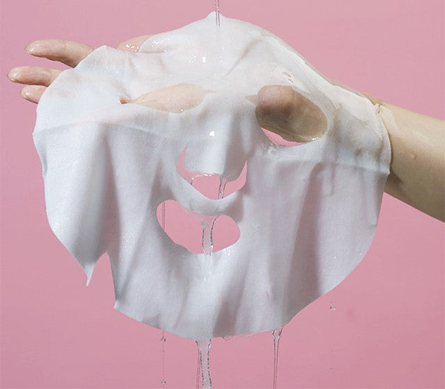 Soaked cotton KAHI Water Full sheet mask held up, dripping with ampoule